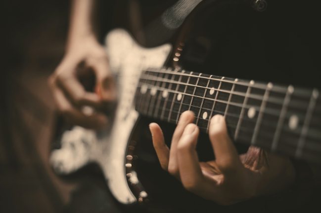 Mãos tocando guitarra de perto