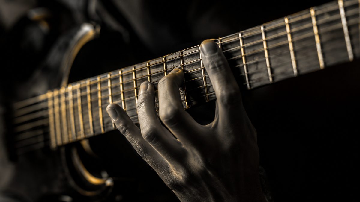 Mãos praticando exercício de técnica na guitarra